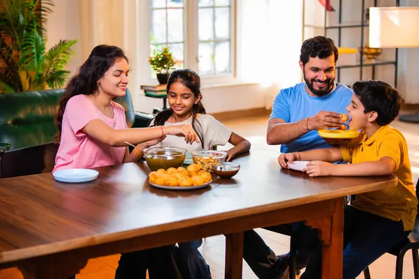 Aile evde panipuri atıştırmalıkları yiyor, Hintli baba, anne, oğul kız rahat oturma odasındaki yemek masasında golgappanın tadını çıkarırken sohbet ediyor, gülüyor ve kaliteli zaman geçiriyor.