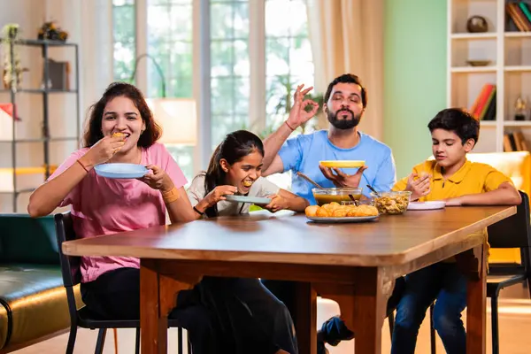 Aile evde panipuri atıştırmalıkları yiyor, Hintli baba, anne, oğul kız rahat oturma odasındaki yemek masasında golgappanın tadını çıkarırken sohbet ediyor, gülüyor ve kaliteli zaman geçiriyor.