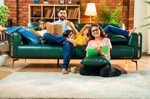 Hintli aile, evdeki rahat kanepede tek başına otururken kitap okuyor. Oğlu olan genç bir çift, kitap okuma alışkanlığıyla kendi kendine gelişim sürecinde.