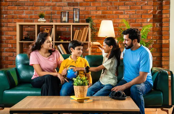 Aile, dünya üzerinde birlikte araştırma yapıyor. İki çocuklu Hintli ebeveynler, ülkelerinin şehirlerini belirlemek için oyuncak dünya modeliyle eğitimsel coğrafya oyunu oynarken evde kaliteli zaman geçiriyorlar.