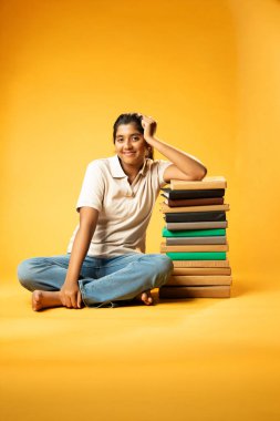 Kitap Yığını, Neşeli Hintli Genç Kız Sarı Kusursuz Geçmişe Oturan Mutlulukla Gülümseyen ve Eğitim Kitapları Yığını Güvenle Dinleyen Olumlu İfade Etme ve Öğrenmenin Keyfi
