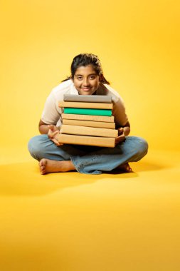 Kitap Yığını, Neşeli Hintli Genç Kız Sarı Kusursuz Geçmişe Oturan Mutlulukla Gülümseyen ve Eğitim Kitapları Yığını Güvenle Dinleyen Olumlu İfade Etme ve Öğrenmenin Keyfi
