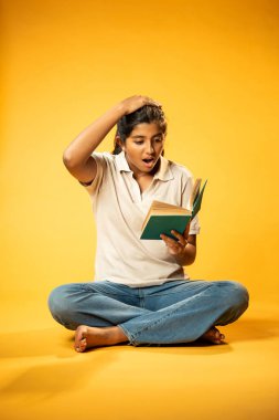 Kitap Okuma, Gergin Hintli Genç Kız Sarı Kusursuz Arkaplanda Oturarak Endişe Gösteriyor, Sınav ve Korku Duyuyor Üzgün Yüz İfadesi ve Düşük Özgüven ile Yalnız Çalışırken