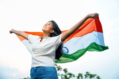 Elinde Hint Bayrağı, Neşeli Genç Kız Rüzgarda Üç Renkli Flütçüler, Mavi Gökyüzü Altında Ulusal Gurur ve Vatanseverlik Gösteren Mutlu Asyalı Çocuk
