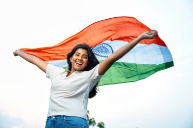Elinde Hint Bayrağı, Neşeli Genç Kız Rüzgarda Üç Renkli Flütçüler, Mavi Gökyüzü Altında Ulusal Gurur ve Vatanseverlik Gösteren Mutlu Asyalı Çocuk