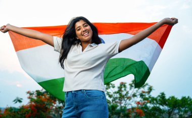 Elinde Hint Bayrağı, Neşeli Genç Kız Rüzgarda Üç Renkli Flütçüler, Mavi Gökyüzü Altında Ulusal Gurur ve Vatanseverlik Gösteren Mutlu Asyalı Çocuk