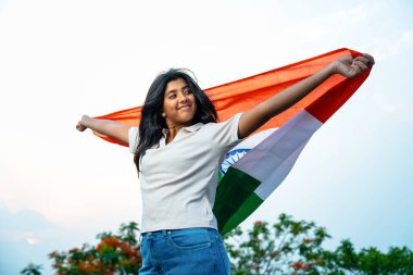 Elinde Hint Bayrağı, Neşeli Genç Kız Rüzgarda Üç Renkli Flütçüler, Mavi Gökyüzü Altında Ulusal Gurur ve Vatanseverlik Gösteren Mutlu Asyalı Çocuk