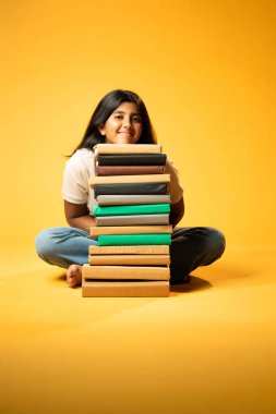 Kitap Yığını, Neşeli Hintli Genç Kız Sarı Kusursuz Geçmişe Oturan Mutlulukla Gülümseyen ve Eğitim Kitapları Yığını Güvenle Dinleyen Olumlu İfade Etme ve Öğrenmenin Keyfi