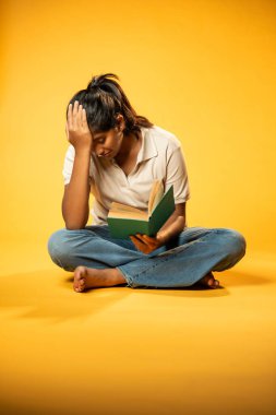Kitap Okuma, Gergin Hintli Genç Kız Sarı Kusursuz Arkaplanda Oturarak Endişe Gösteriyor, Sınav ve Korku Duyuyor Üzgün Yüz İfadesi ve Düşük Özgüven ile Yalnız Çalışırken