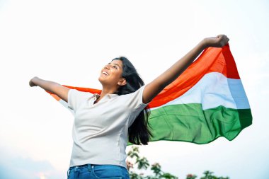 Elinde Hint Bayrağı, Neşeli Genç Kız Rüzgarda Üç Renkli Flütçüler, Mavi Gökyüzü Altında Ulusal Gurur ve Vatanseverlik Gösteren Mutlu Asyalı Çocuk