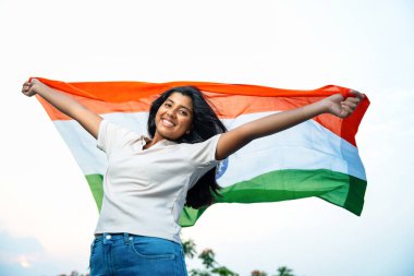 Elinde Hint Bayrağı, Neşeli Genç Kız Rüzgarda Üç Renkli Flütçüler, Mavi Gökyüzü Altında Ulusal Gurur ve Vatanseverlik Gösteren Mutlu Asyalı Çocuk