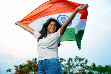 Elinde Hint Bayrağı, Neşeli Genç Kız Rüzgarda Üç Renkli Flütçüler, Mavi Gökyüzü Altında Ulusal Gurur ve Vatanseverlik Gösteren Mutlu Asyalı Çocuk