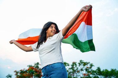 Elinde Hint Bayrağı, Neşeli Genç Kız Rüzgarda Üç Renkli Flütçüler, Mavi Gökyüzü Altında Ulusal Gurur ve Vatanseverlik Gösteren Mutlu Asyalı Çocuk