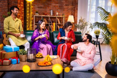 Arkadaşlar Diwali 'yi çay, Hint Asyalı aile ve geleneksel şenlik kıyafetleriyle kutluyorlar. Hint festivali Deepavali' nin tadını çıkarıyorlar. Süslü evde çay ya da kahveyi klasik bir çömlekle yudumluyorlar.