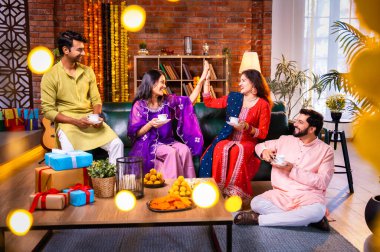 Arkadaşlar Diwali 'yi çay, Hint Asyalı aile ve geleneksel şenlik kıyafetleriyle kutluyorlar. Hint festivali Deepavali' nin tadını çıkarıyorlar. Süslü evde çay ya da kahveyi klasik bir çömlekle yudumluyorlar.