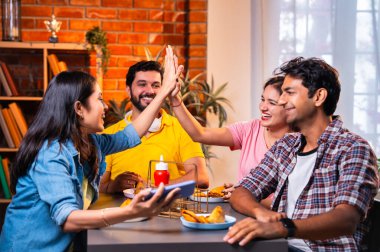 Kafede komik videolar izliyorlar, Hintli Asyalı genç üniversite arkadaşları ya da üniversite öğrencileri samosa yerken yüksek sesle gülüyorlar, sıcak çay yudumluyorlar, kapalı alanda komedi kliplerinin keyfini çıkarıyorlar.