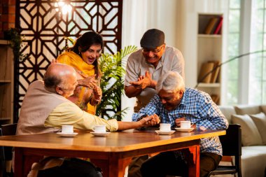 Hint son sınıf öğrencileri yemek masasında bilek güreşi ya da dostça panja oyunu oynuyorlar, ev içinde neşeyle yarışıyorlar, Asyalı yaşlı adamlar evde eğlenirken eğleniyorlar ve tezahürat yapıyorlar.