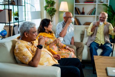 Son sınıflar sıcak çay içerken rahat koltukta otururken Hindistan 'daki Asya' lı yaşlı arkadaşlar evlerinde sıcak içeceklerin keyfini çıkarıyorlar.