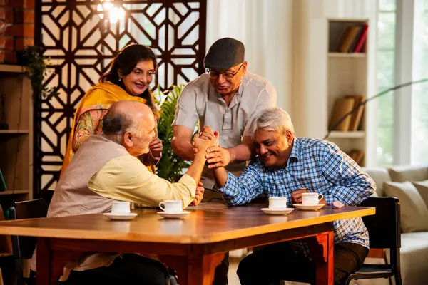 Hint son sınıf öğrencileri yemek masasında bilek güreşi ya da dostça panja oyunu oynuyorlar, ev içinde neşeyle yarışıyorlar, Asyalı yaşlı adamlar evde eğlenirken eğleniyorlar ve tezahürat yapıyorlar.