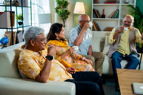 Son sınıflar sıcak çay içerken rahat koltukta otururken Hindistan 'daki Asya' lı yaşlı arkadaşlar evlerinde sıcak içeceklerin keyfini çıkarıyorlar.