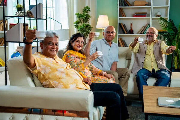 Son sınıflar sıcak çay içerken rahat koltukta otururken Hindistan 'daki Asya' lı yaşlı arkadaşlar evlerinde sıcak içeceklerin keyfini çıkarıyorlar.