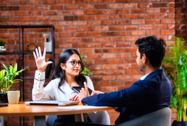 Hintli iş adamları dizüstü bilgisayar ve belge kullanıyorlar, Asyalı kurumsal erkek ve kadın resmi giyinmiş raporları tartışıyorlar, modern ofis masasında dizüstü bilgisayarla birlikte çalışıyorlar, takım çalışması kavramı.