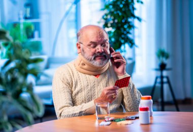 Hintli kıdemli doktor, elinde ilaç şeridi ya da şişesi olan doktoru arıyor. Yaşlı kişi, düşünceli bir aile içi sağlık durumunun dozajı ya da yan etkileri hakkında telefonla danışmanlık yapıyor.
