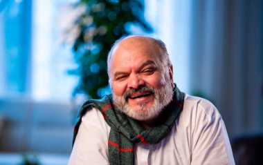 Hintli kıdemli bir adam derin düşüncelere dalmış parlak, modern bir evde koltukta otururken düşünceli, asyalı, yaşlı ve endişeli bir yüz ifadesi olan yaşlı bir adam kapalı alanda ciddi düşüncelere dalmış.