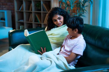 Hint anne oğlu, modern evdeki kanepede rahat bir şala sarılı otururken birlikte masal kitabı okuyor. Bağlanma zamanını, sıcaklığı, sevgiyi, ebeveyn çocuk ilişkisini, kapalı bir yerde yaşam tarzını paylaşıyor.