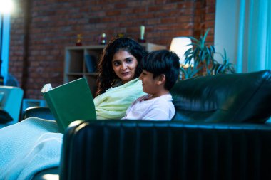 Hint anne oğlu, modern evdeki kanepede rahat bir şala sarılı otururken birlikte masal kitabı okuyor. Bağlanma zamanını, sıcaklığı, sevgiyi, ebeveyn çocuk ilişkisini, kapalı bir yerde yaşam tarzını paylaşıyor.