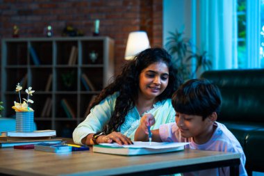 Hintli oğul aletle geometri öğrenirken, anne de modern evde merakla izliyor, birlikte kaliteli oyun zamanı geçiriyor, becerileri geliştiriyor, neşe paylaşıyor, ebeveyn bağı kuruyor, öğrenme yetisini geliştiriyor.