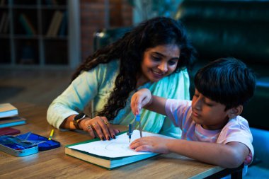 Hintli oğul aletle geometri öğrenirken, anne de modern evde merakla izliyor, birlikte kaliteli oyun zamanı geçiriyor, becerileri geliştiriyor, neşe paylaşıyor, ebeveyn bağı kuruyor, öğrenme yetisini geliştiriyor.