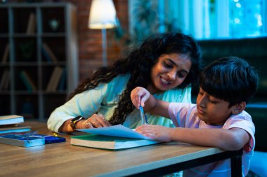 Hintli oğul aletle geometri öğrenirken, anne de modern evde merakla izliyor, birlikte kaliteli oyun zamanı geçiriyor, becerileri geliştiriyor, neşe paylaşıyor, ebeveyn bağı kuruyor, öğrenme yetisini geliştiriyor.