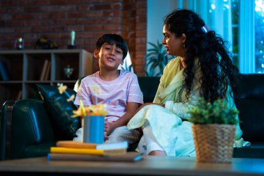 Hintli anne küçük çocuk kanepenin üzerinde modern evde sohbet ediyor, birlikte kaliteli zaman geçiriyorlar, sevgi, sevgi, sıcaklık, ilgi, mutluluk, ebeveyn-çocuk ilişkisi günlük rutin yaşam tarzı.