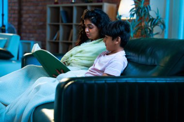 Hint anne oğlu, modern evdeki kanepede rahat bir şala sarılı otururken birlikte masal kitabı okuyor. Bağlanma zamanını, sıcaklığı, sevgiyi, ebeveyn çocuk ilişkisini, kapalı bir yerde yaşam tarzını paylaşıyor.