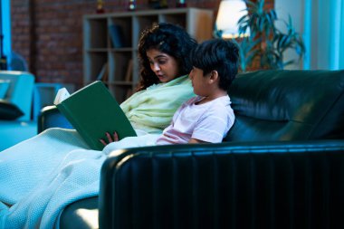 Hint anne oğlu, modern evdeki kanepede rahat bir şala sarılı otururken birlikte masal kitabı okuyor. Bağlanma zamanını, sıcaklığı, sevgiyi, ebeveyn çocuk ilişkisini, kapalı bir yerde yaşam tarzını paylaşıyor.