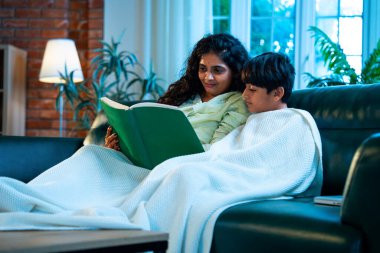 Hint anne oğlu, modern evdeki kanepede rahat bir şala sarılı otururken birlikte masal kitabı okuyor. Bağlanma zamanını, sıcaklığı, sevgiyi, ebeveyn çocuk ilişkisini, kapalı bir yerde yaşam tarzını paylaşıyor.