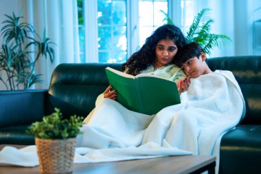 Hint anne oğlu, modern evdeki kanepede rahat bir şala sarılı otururken birlikte masal kitabı okuyor. Bağlanma zamanını, sıcaklığı, sevgiyi, ebeveyn çocuk ilişkisini, kapalı bir yerde yaşam tarzını paylaşıyor.