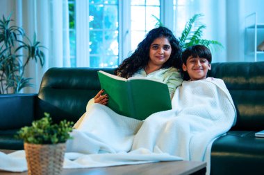 Hint anne oğlu, modern evdeki kanepede rahat bir şala sarılı otururken birlikte masal kitabı okuyor. Bağlanma zamanını, sıcaklığı, sevgiyi, ebeveyn çocuk ilişkisini, kapalı bir yerde yaşam tarzını paylaşıyor.