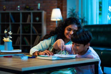 Hintli oğul aletle geometri öğrenirken, anne de modern evde merakla izliyor, birlikte kaliteli oyun zamanı geçiriyor, becerileri geliştiriyor, neşe paylaşıyor, ebeveyn bağı kuruyor, öğrenme yetisini geliştiriyor.