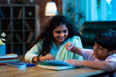 Hintli oğul aletle geometri öğrenirken, anne de modern evde merakla izliyor, birlikte kaliteli oyun zamanı geçiriyor, becerileri geliştiriyor, neşe paylaşıyor, ebeveyn bağı kuruyor, öğrenme yetisini geliştiriyor.