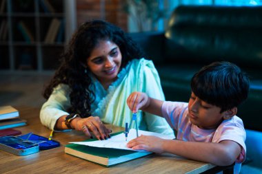 Hintli oğul aletle geometri öğrenirken, anne de modern evde merakla izliyor, birlikte kaliteli oyun zamanı geçiriyor, becerileri geliştiriyor, neşe paylaşıyor, ebeveyn bağı kuruyor, öğrenme yetisini geliştiriyor.