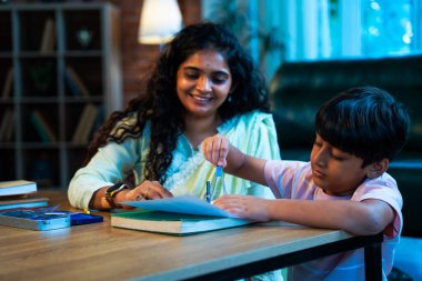 Hintli oğul aletle geometri öğrenirken, anne de modern evde merakla izliyor, birlikte kaliteli oyun zamanı geçiriyor, becerileri geliştiriyor, neşe paylaşıyor, ebeveyn bağı kuruyor, öğrenme yetisini geliştiriyor.