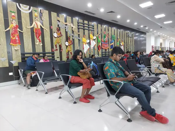 Chennai, Madras, Hindistan, 8 Nisan 2023: Ev içi dinlenme yeri, dekoratif bir geçmişe sahip uçuş için zaman geçirmek amacıyla cep telefonu çalan turist