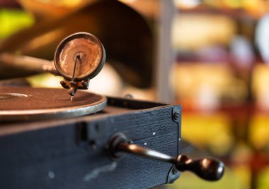 Eski bir fonograf iğnesi ve kolunun bulanık arka planı olan bir pikapta detaylı bir yakın plan çekimi.