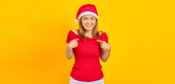 Vrolijke Jonge Vrouw Met Kerstmuts Wijzend Naar Zichzelf Gele Achtergrond — Stockfoto