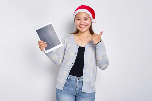 Uśmiechnięta Młoda Azjatka Kapeluszu Boże Narodzenie Pokazuje Pusty Ekran Tabletki Zdjęcie Stockowe