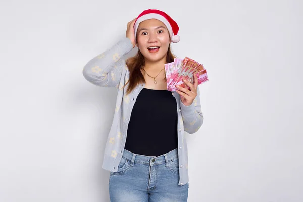 Podekscytowana Młoda Azjatka Ubrana Świąteczny Kapelusz Trzymająca Pieniądze Rupii Odizolowane Obrazek Stockowy