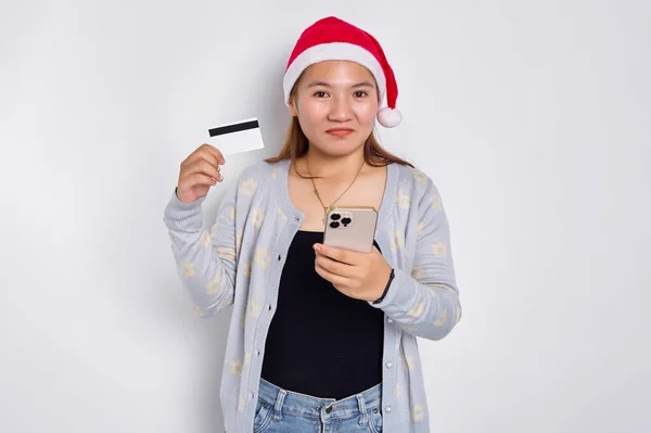 Wesoła Młoda Azjatka Świątecznym Kapeluszu Telefonem Komórkowym Białą Kartą Kredytową Zdjęcia Stockowe bez tantiem