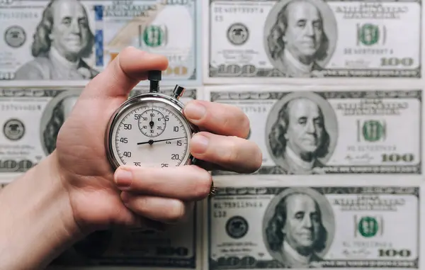 女人的手拿着秒表挡住了美元的背景 快钱的时间到了 — 图库照片